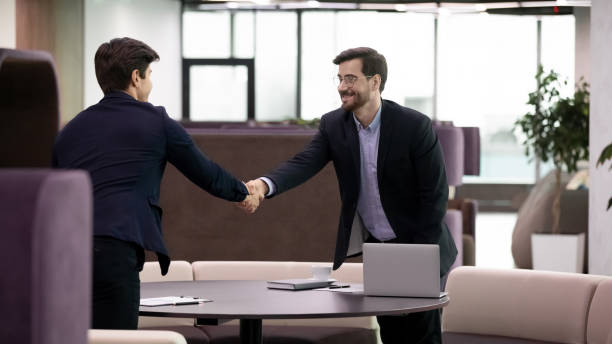 istock Successful job interview, business man handshaking with young candidate 1253731508