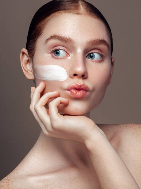 istock Young girl inflicts cream on her face 1253731611