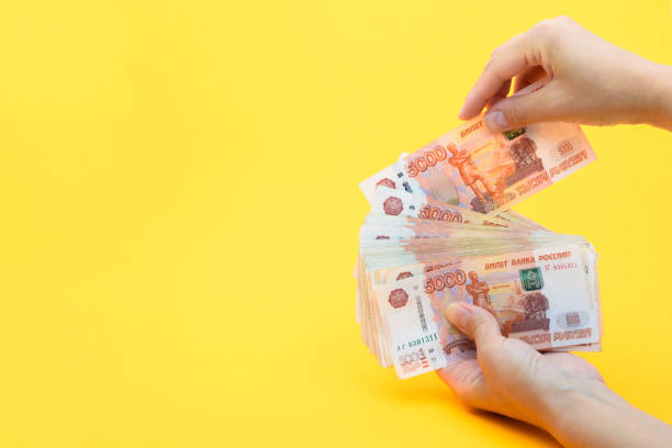 istock Hands put another bill in a pack of five thousandth bills 1253733628