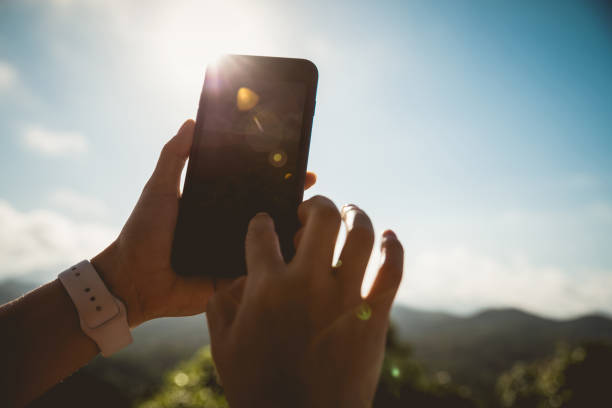 istock Hands using mobile phone taking picture in sunrise nature 1253733794