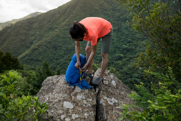 istock successful woman hiker packing the backpack hiking on cliff edge 1253736300