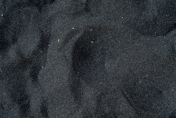 istock Black sand beach macro photography. Silky black beach texture. Minimalistic black background. Tenerife voulcanic sandy shore. 1253738461