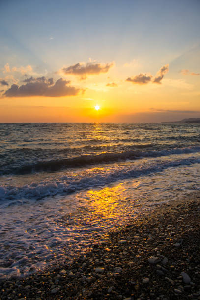 istock Amazing sea sunset on the pebble beach, the sun, waves, clouds 1253738558