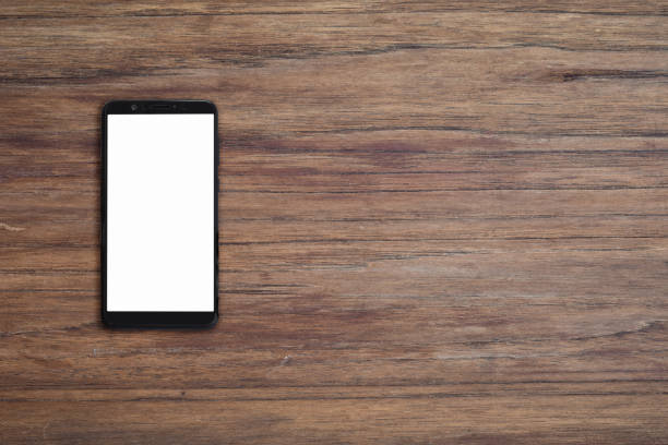istock Mobile smartphone with blank screen on wood desk 1253739492