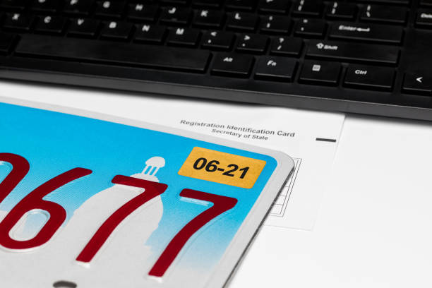 vehicle license plate, renewal sticker, computer keyboard and registration card. concept of state government automobile fees, transportation taxes, funding and online renewal - secretary of state imagens e fotografias de stock