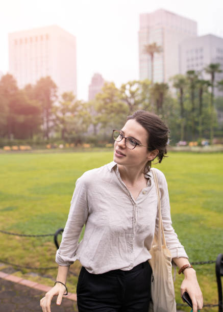 istock Young woman walking in public park 1253741965