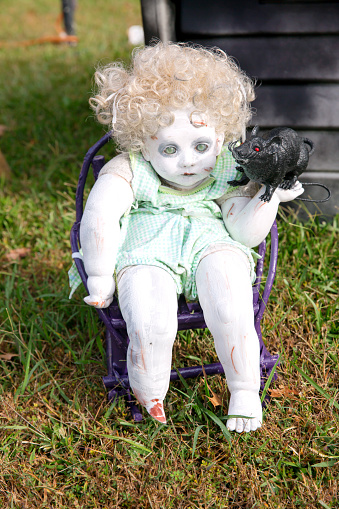 Outdoor Halloween decoration with DIY doll holding rodent
