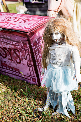 DIY scary doll stands by toy chest in yard display