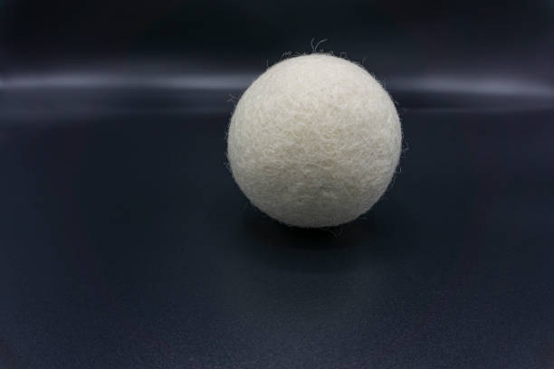 Reusable wool dryer ball as a fabric softener, isolated on gray background.