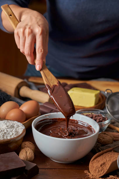istock Woman hands making chocolate mousse and cookies on a wooden table in a rustic kitchen 1253760038