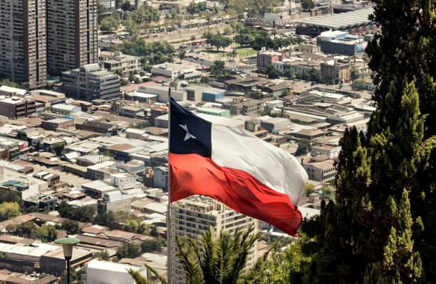 de chileense vlag wappert, met de stad santiago de chile als achtergrond. - chili fire stockfoto's en -beelden