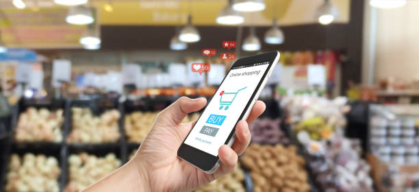istock Man hand holding smartphone device and touching screen. Online shopping 1253781947