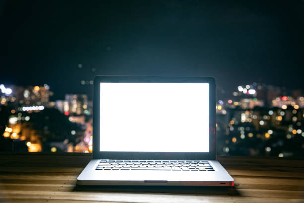 istock Laptop on table at night city 1253792665