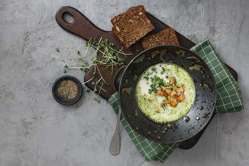 Skagen Fish Soup Green Herb Oil. Tradition Danish Soup. Flat lay top-down composition on concrete background. Horizontal image with copy space.