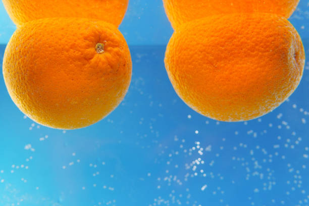 naranjas en el agua bajo la fruta del agua - splashing orange fruit water fotografías e imágenes de stock