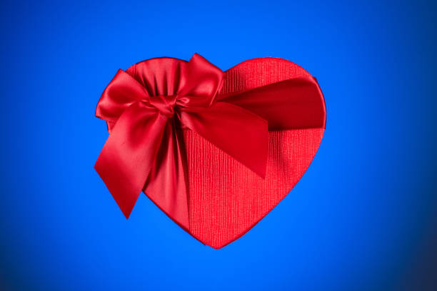 istock Red heart gift box on blue background 1253801634