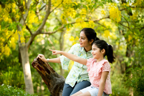istock Mother and daughter admiring view at park 1253801855