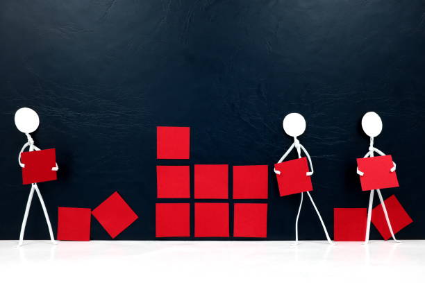 istock Teamwork, cooperation and rebuilding business concept. Human stick figures fixing broken red building blocks. 1253802219
