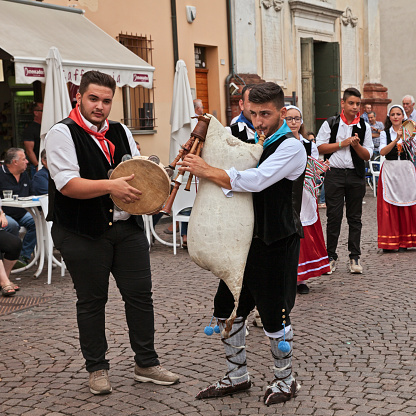 Russi, Ravenna, Italy - August 2, 2015: musicians of folk ensemble Irizema from Bova Marina, Calabria, Italy, play tarantella with tambourine and Italian bagpipe zampogna during the International Folklore Festival
