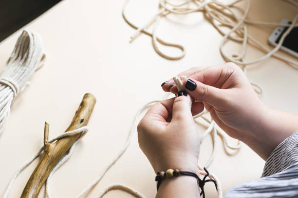 istock Female hands weave macrame the home workshop. Boho lifestyle. Hobby hobby concept. Selective focus horizontal frame. 1253803276