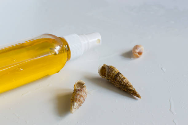 istock Massage oil. Spa aromatherapy. Spray for tanning. Marine concept. Seashells. 1253805152
