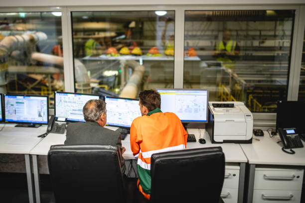 istock Worker and Manager Sitting in Control Room of Waste Facility 1253813452
