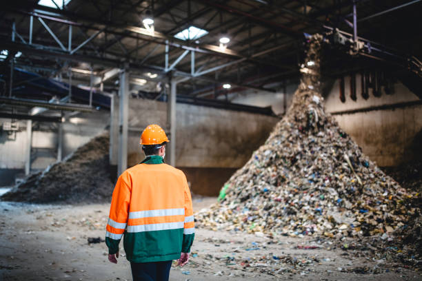 istock Male Recycling Expert Observing Pile of Processed Waste 1253813475