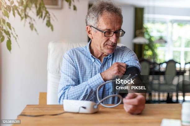 Senior Mann Mit Medizinischen Geräten Um Blutdruck Zu Messen Stockfoto und mehr Bilder von Blutdruckmesser
