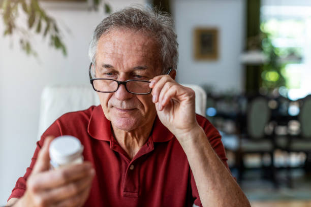 hogere mens die voorschriftgeneeskunde thuis neemt - pillenpotje stockfoto's en -beelden