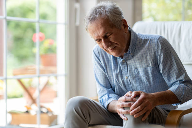 hombre mayor con dolor de rodilla - pain joint human hand arthritis fotografías e imágenes de stock