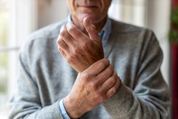 starszy mężczyzna z zapaleniem stawów pocieranie rąk - arthritis senior adult rheumatoid arthritis sadness zdjęcia i obrazy z banku zdjęć