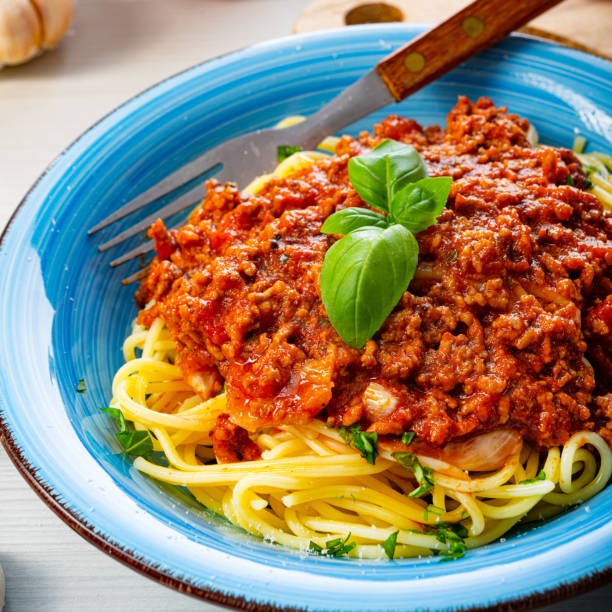 istock Delicious spaghetti bolognese on white background 1253818538