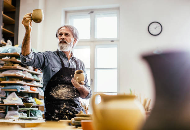 istock Craftsperson examining his finished pottery 1253818562