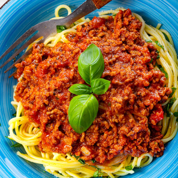 istock Delicious spaghetti bolognese on white background 1253818587