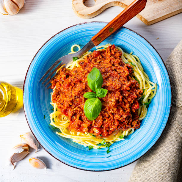 istock Delicious spaghetti bolognese on white background 1253819197