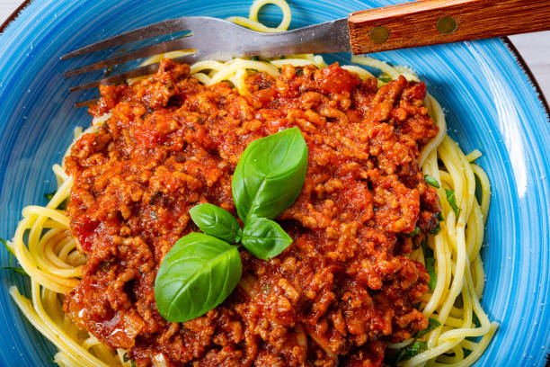 istock Delicious spaghetti bolognese on white background 1253819374