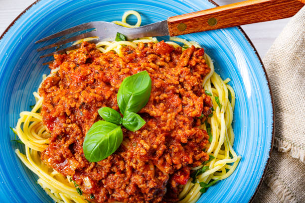 istock Delicious spaghetti bolognese on white background 1253819495