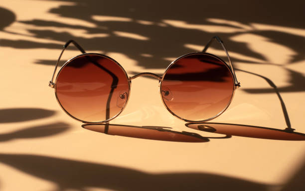 istock Brown sunglasses in a round shape. Bright sunlight. 1253819813