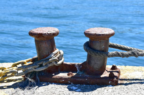istock Rusty iron mooring post close-up in a harbor. 1253819834