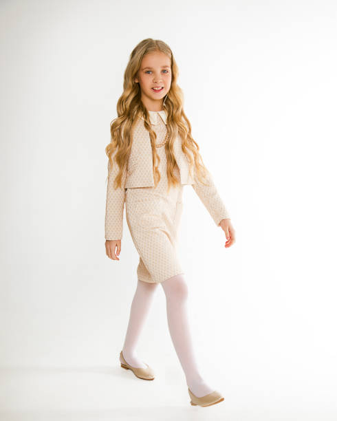 photo of a beautiful blonde girl with long hair in curls in stylish fashionable clothes look at the camera on a white background in full growth. isolated. school girl 8-10 years old. go back to school - 10 11 years child human face female imagens e fotografias de stock