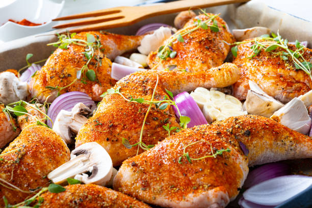 istock Prepared chicken legs with various vegetables and herbs 1253820833