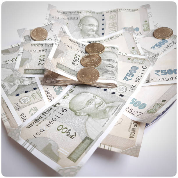 istock Indian new 500 rupees currency notes spread randomly with 5 rupee coins in white paper 1253822505