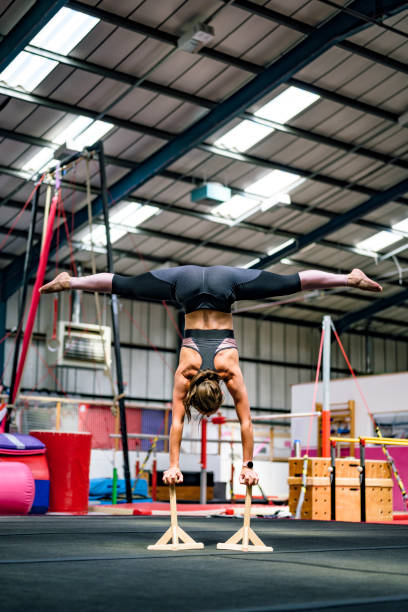 istock Skilled female athlete balancing on handstand canes 1253823325