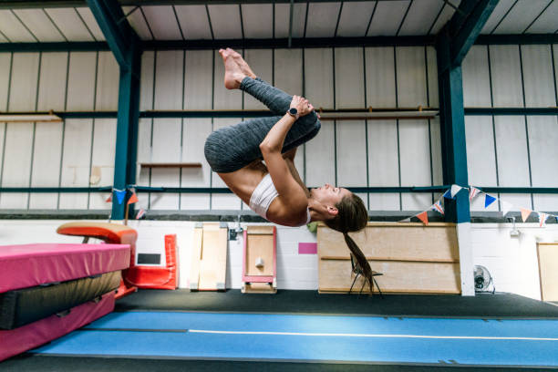 athlète féminine en forme au début des années 30 pratiquant flip dans la salle de gym - gymnastique au sol photos et images de collection