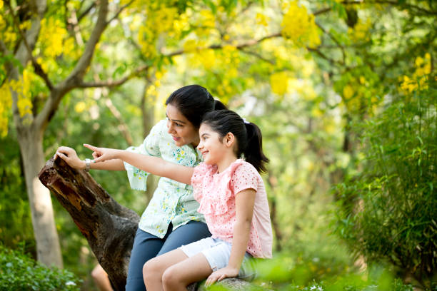 istock Mother and daughter admiring view at park 1253823425