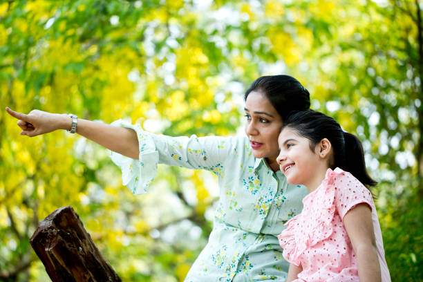 istock Mother and daughter admiring view at park 1253823615