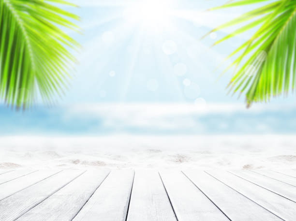 istock Wooden table top on blue sea and white sand beach background. 1253824908