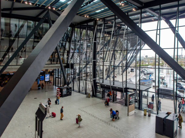 Saint Exupery Airport in Lyon, France. This is a view of the airport entrance with views through windows to the outside of the airport and people leaving the airport or waiting for friends or transport.