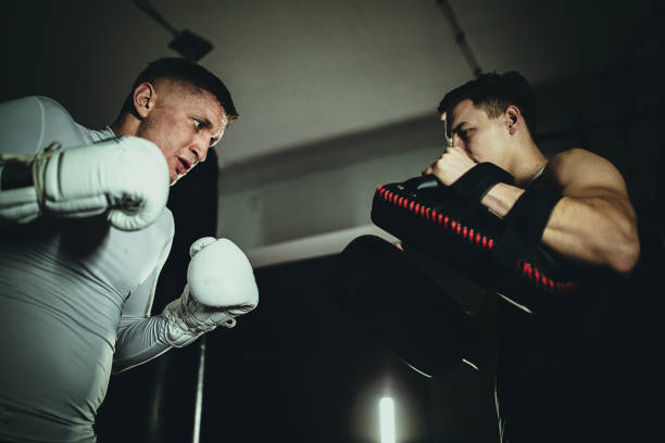 istock Young men sparring together on kick box training in the gym 1253828227