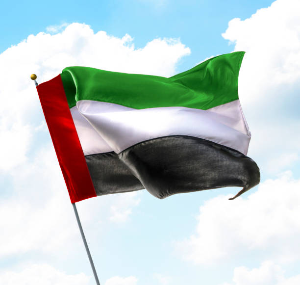 Flag of UAE Flag of United Arab Emirates Raised Up in The Sky hoisting photos stock pictures, royalty-free photos & images
